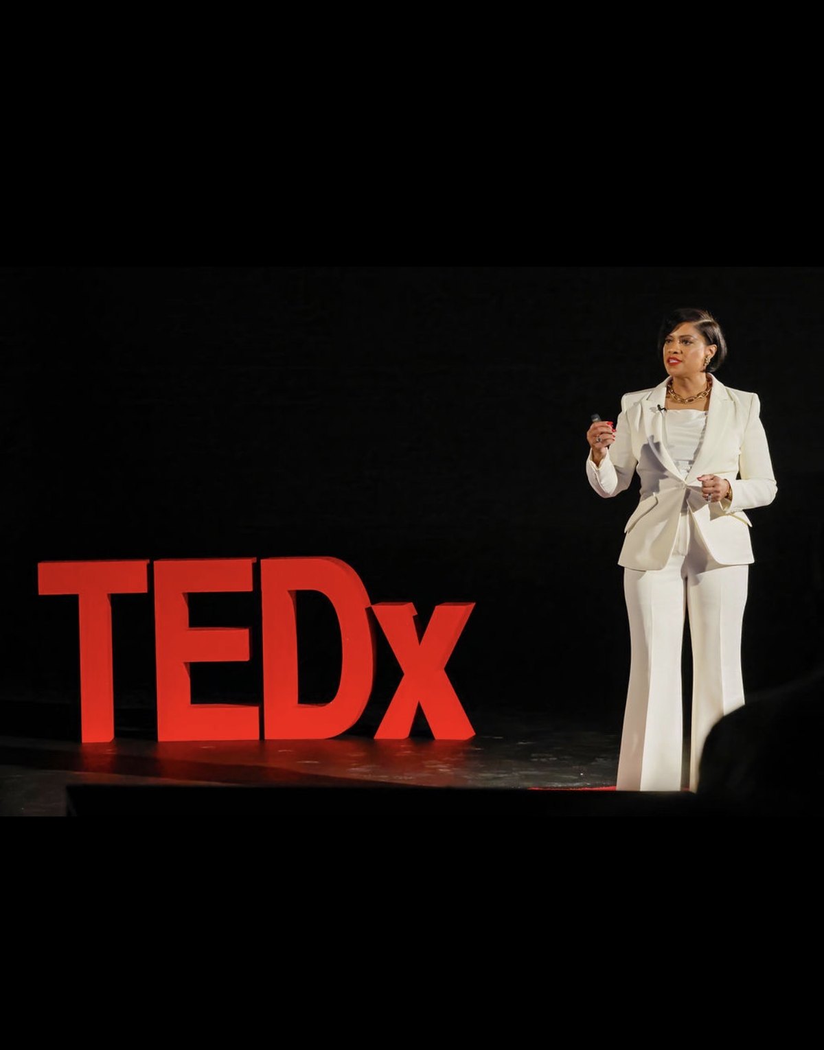 Tammie Ross delivering her TEDx talk on the TEDx Apex stage